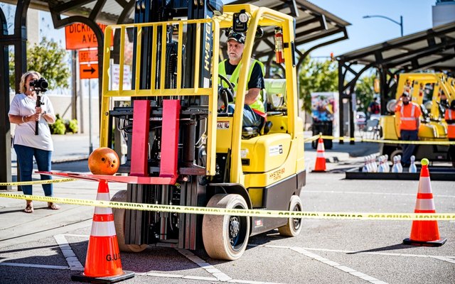 Оператор осматривает погрузчик перед началом смены на складе